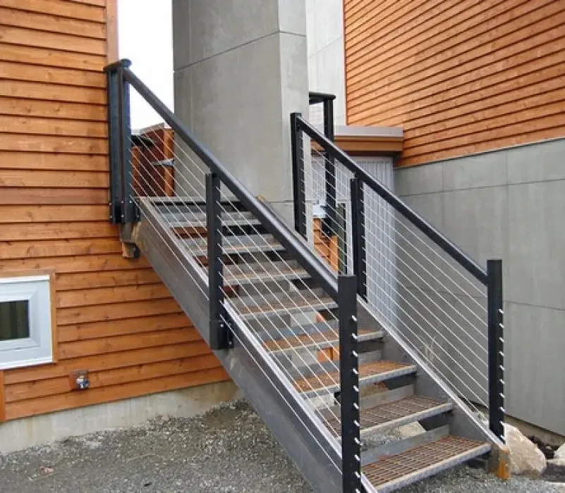 Exterior metal entry stairs and railing between wood-clad walls