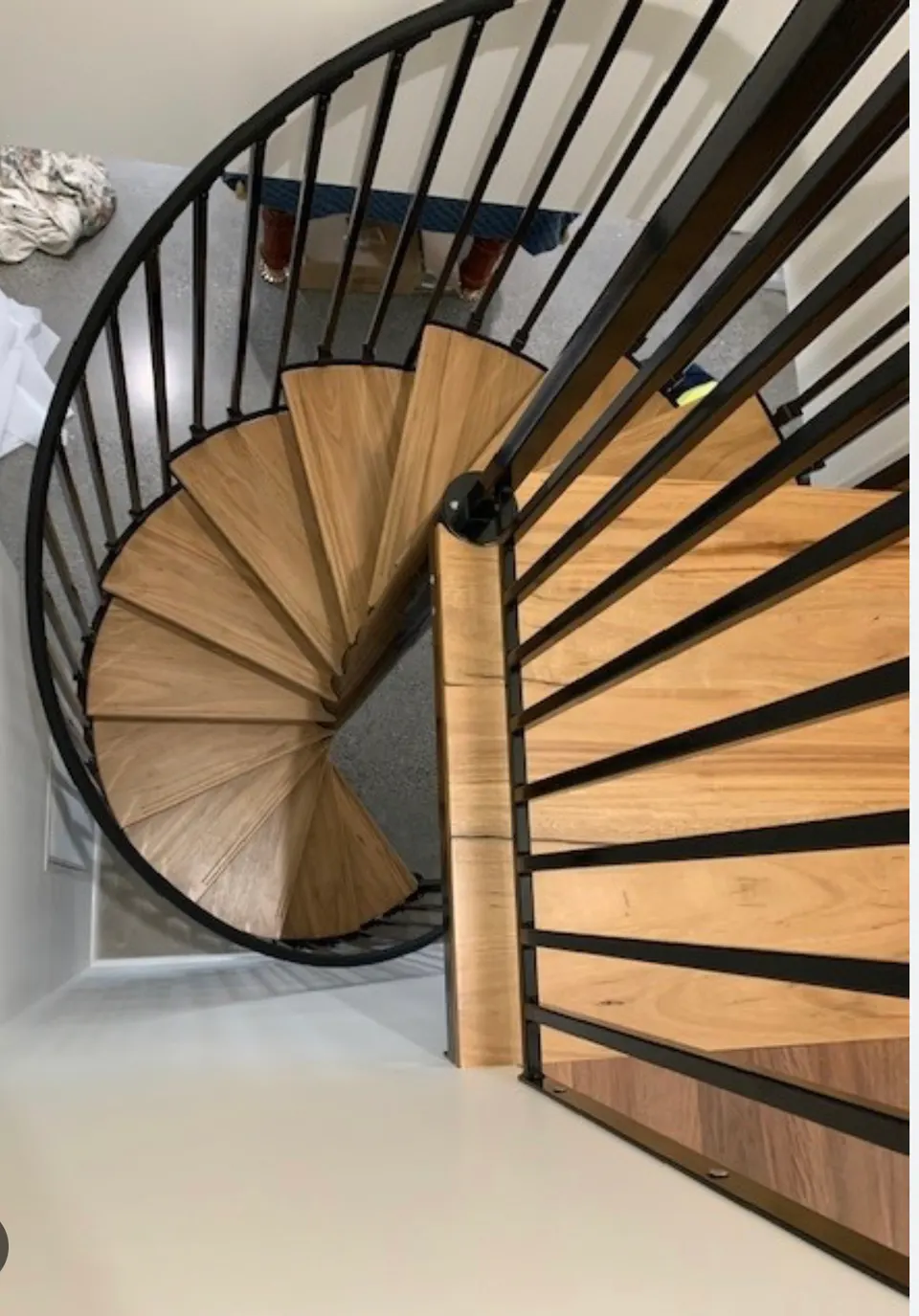 Overhead view of a spiral stair with wood treads and black balusters