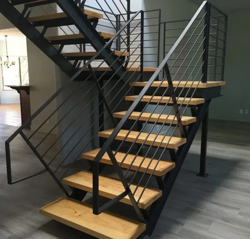 Black steel staircase with warm wood treads and slender metal railing